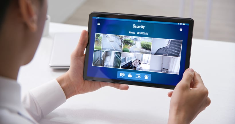 Man Watching Home Security Cameras in Tablet