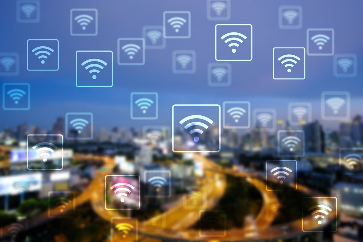 WiFi network on blurred cityscape background.